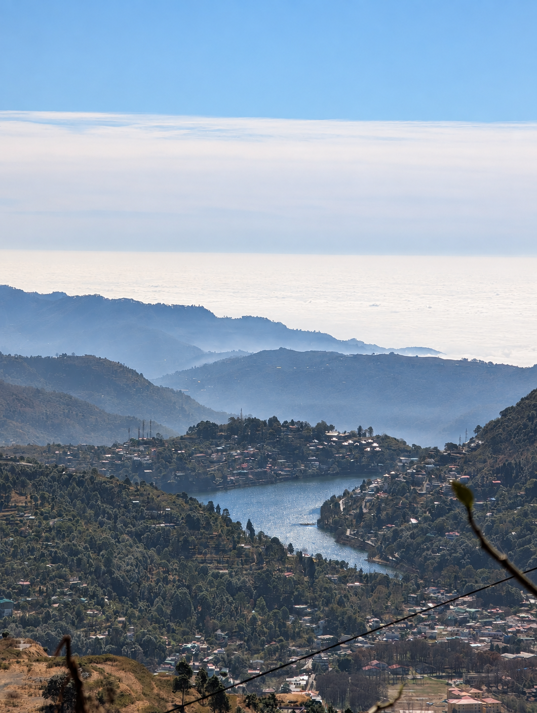 Mist hanging over the hills and Bhimtal Lake as seen from Golu Devta Temple